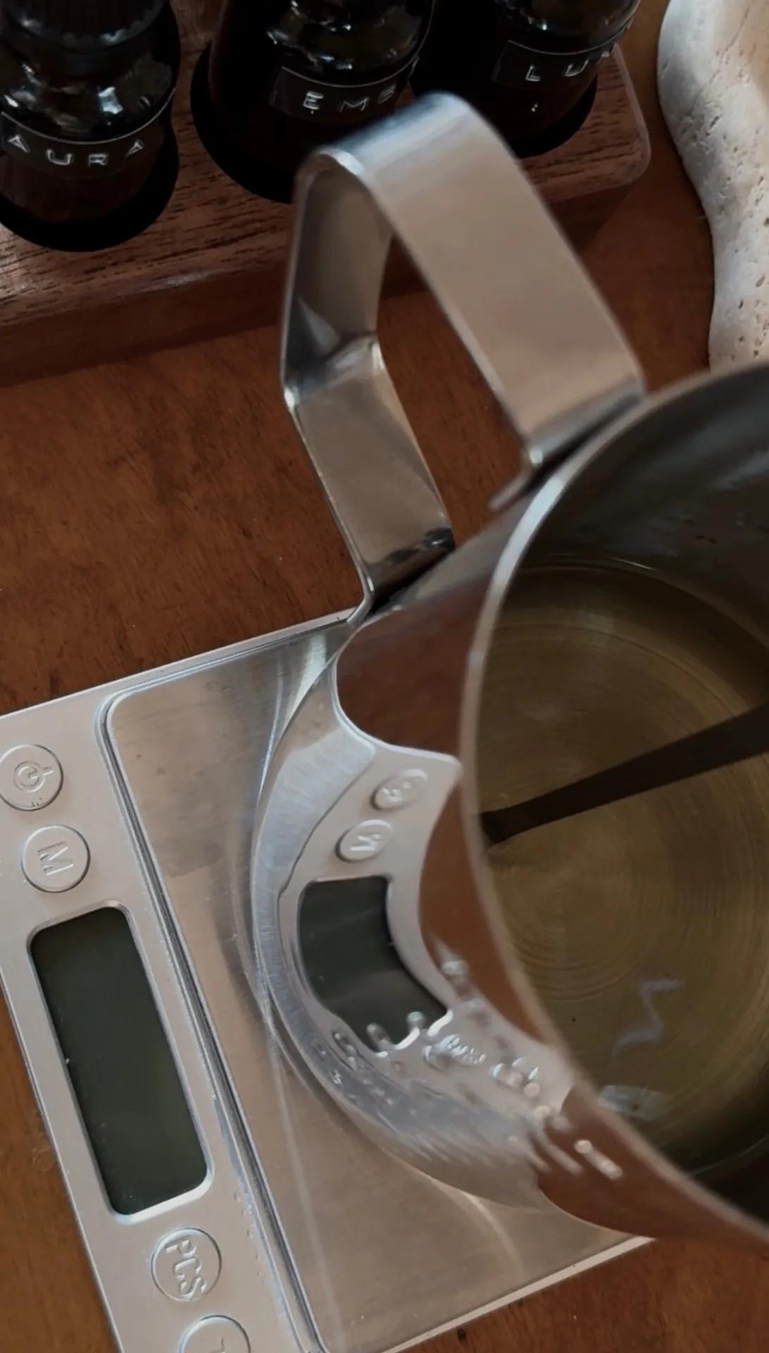 Essential oils being weighed and poured into a steel vessel in the LUĒR studio