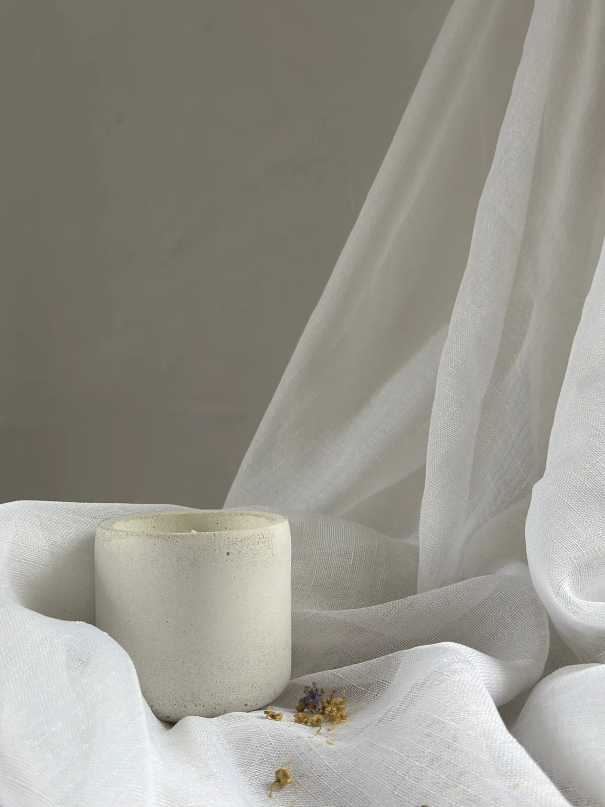 Aura — LUĒR candle with dried chamomile and lavender on soft fabric