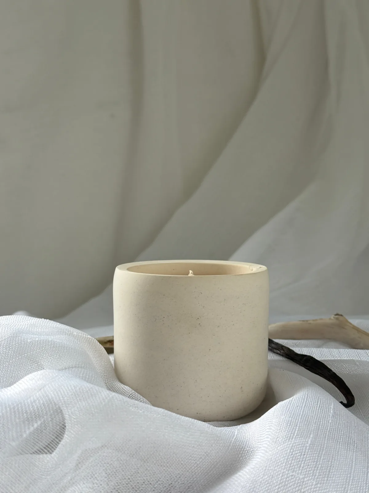 Lune — LUĒR ritual candle on white linen with a dried branch